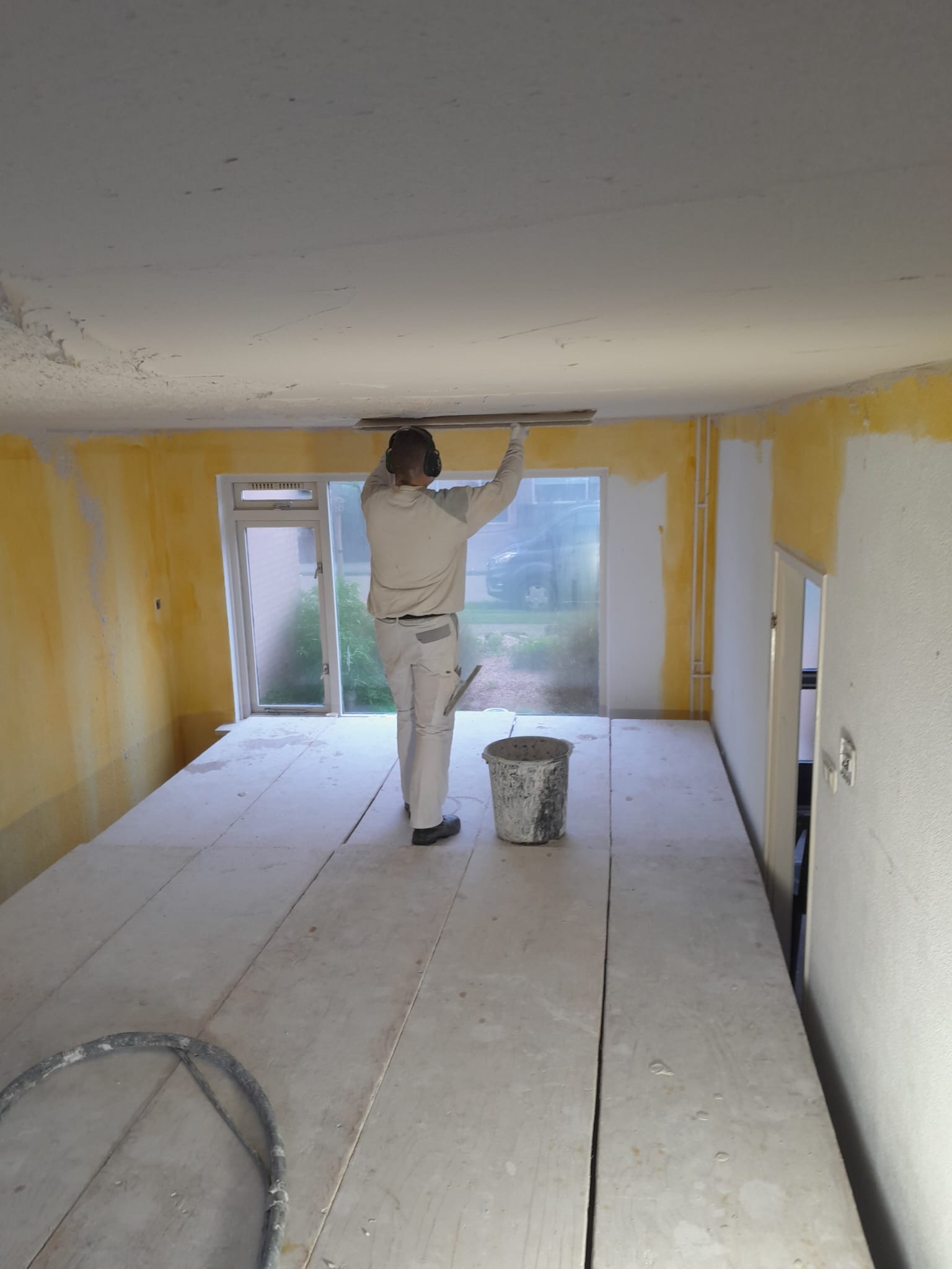 Hans Huisman aan het werk tijdens het stucen van een plafond