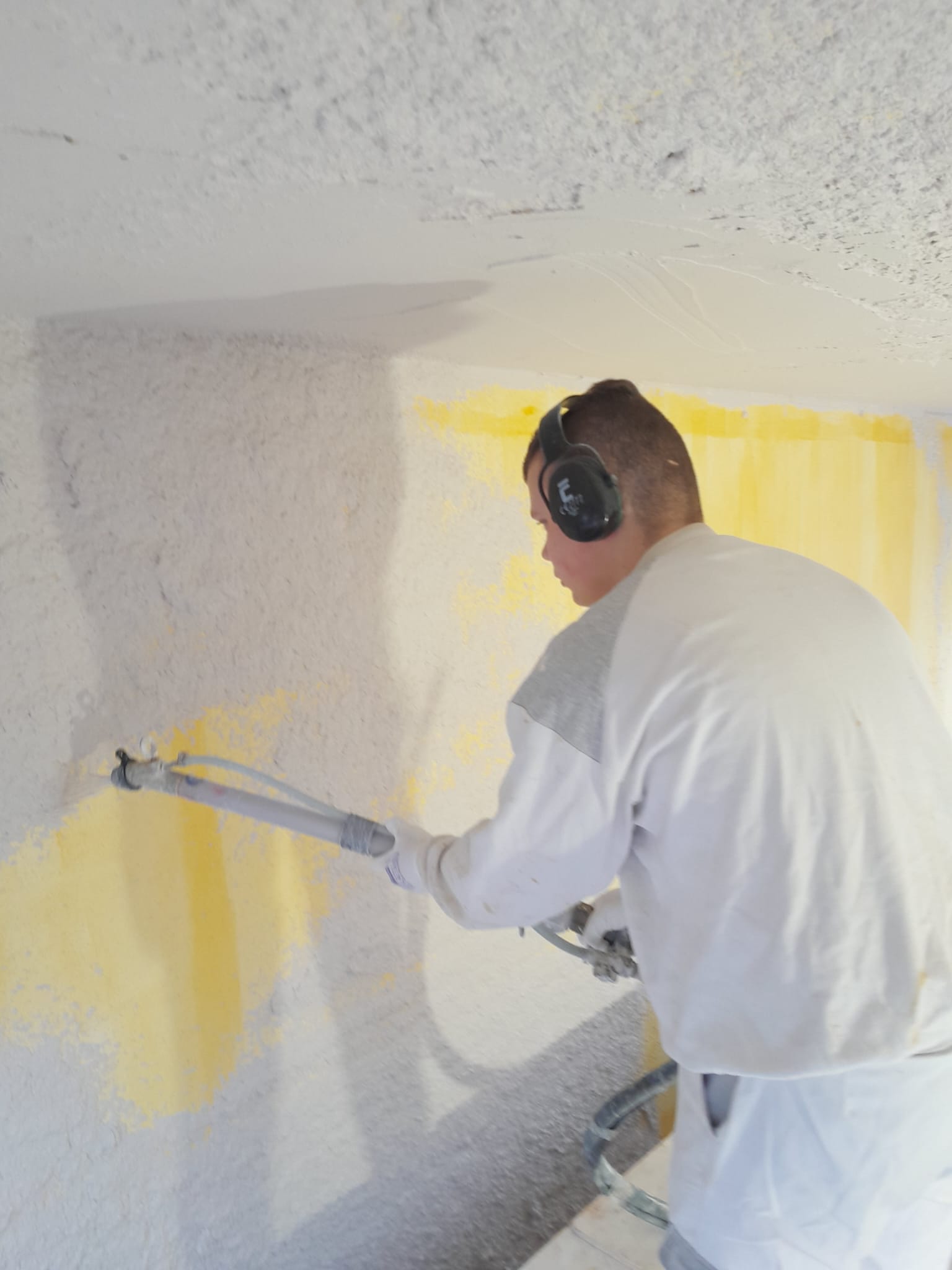 Robin Huisman aan het werk tijdens het stucen van een wand